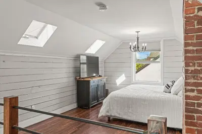 a bedroom with a bed and a television in a room at Stunning Heritage Home, Sleep 8, Hot Tub, Private Yard, Firepit in Vernon