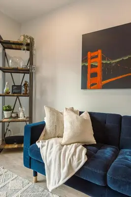 a blue couch sitting in a living room at Revelstoke Alpine Retreat - RARE One-Bedroom Condo in Revelstoke