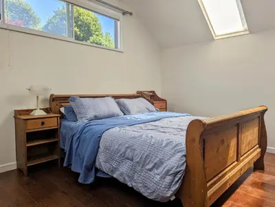 a bedroom with a wooden bed and a window at Ocean Park Loft in Surrey