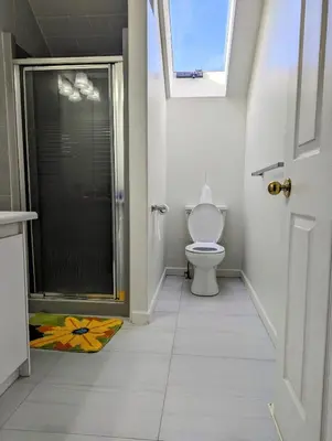 a bathroom with a toilet and a walk in shower at Ocean Park Loft in Surrey