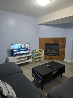 a living room with a couch and a flat screen tv at Private basement suite in Langley