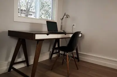a desk with a laptop and a chair in a room at Private Suite Steps to Main St. in Vancouver