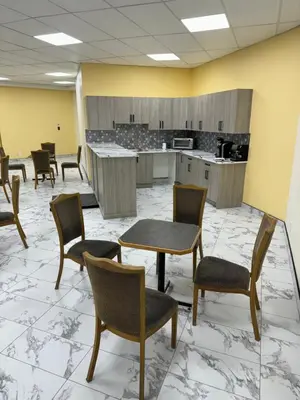 a waiting room with chairs and tables and a kitchen at The Viking Inn in Viking