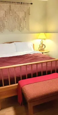 a bedroom with a bed and a lamp and a bench at EVCharger, Free Parking, Ski, Golf, BBQ, Awesomeness in Invermere