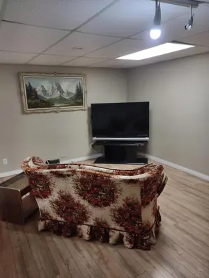 a living room with a couch and a flat screen tv at A Place to Call Home in Edmonton