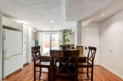 a kitchen and dining room with a table and chairs at Simplistic 2BR Suite near Nose Hill & Airport in Calgary
