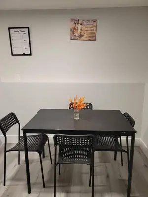 a black table with chairs and a vase with flowers on it at Private Family Hideaway or Business Travel in Edmonton - 2 Bedroom Apartment in Edmonton
