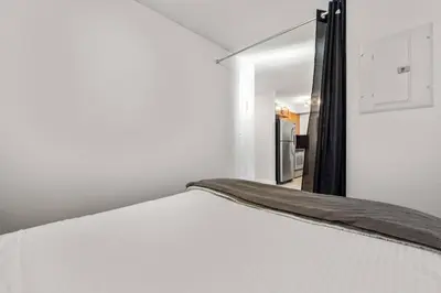 a bed in a room with a door leading to a kitchen at Lakeside Memories, Pool, Hot Tub, Central in Invermere