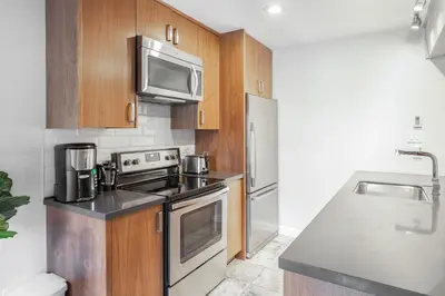 a kitchen with stainless steel appliances and wooden cabinets at Whistler Studio by Gondola & Free Parking in Whistler
