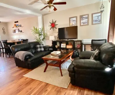 a living room with two black couches and a coffee table at Mountain View Executive Suite in Grande Cache