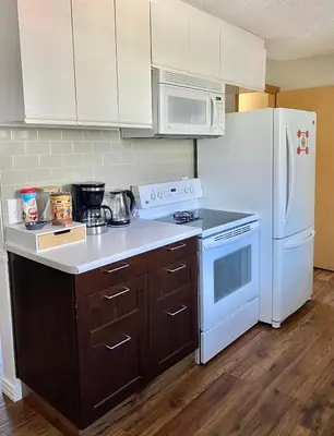 a kitchen with white appliances and a white refrigerator at Mountain View Executive Suite in Grande Cache
