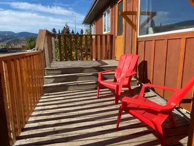two red chairs sitting on a wooden deck at Mountain View Executive Suite in Grande Cache