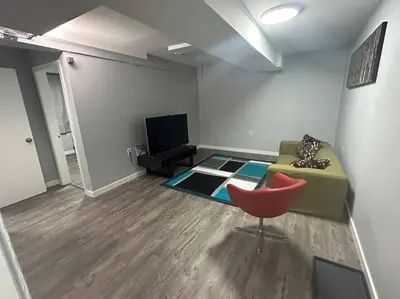 a living room with a couch and a red chair at Cute Highland Park Entire Unit B in Calgary