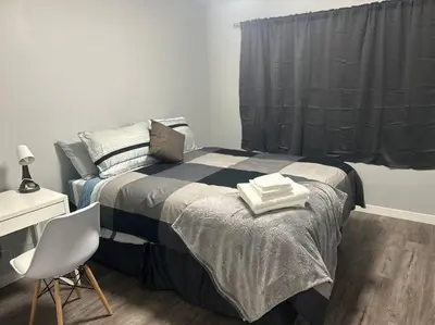 a bedroom with a bed with two towels on it at Cute Highland Park Entire Unit B in Calgary