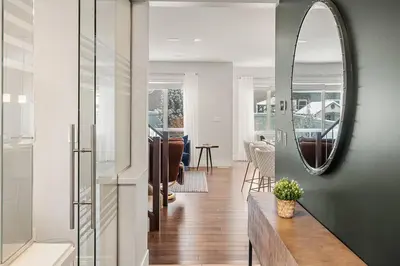 a living room with a mirror on the wall at Luxurious Entire House with Cental AC, Double Car Garage Parking, Upgraded Appliances, King Size Bed, Two Living Rooms & More in Nisku