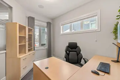 an office with a desk and a black chair at Luxurious Entire House with Cental AC, Double Car Garage Parking, Upgraded Appliances, King Size Bed, Two Living Rooms & More in Nisku