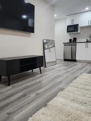 a living room with a table and a kitchen at Trendy 2-Bed Oasis Awaits! in Calgary