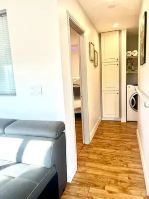 a living room with a blue couch and a hallway at Westview Vacation Rental - Two BR House in North Vancouver