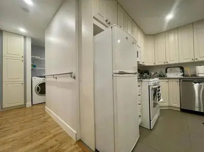a large kitchen with white cabinets and appliances at Westview Vacation Rental - Two BR House in North Vancouver