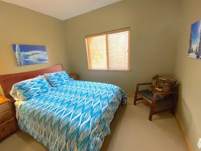 a bedroom with a bed and a window and a chair at Morrisey Chalet at Sun Peaks in Sun Peaks