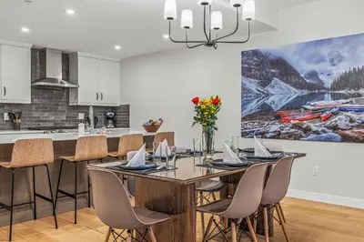 a kitchen and dining room with a table and chairs at Brand New - TimberLodge Spacious 2br in Canmore