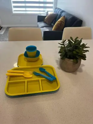 a yellow tray on a table with a cup and scissors at Brand New - Home Away from Home in NW Calgary in Calgary