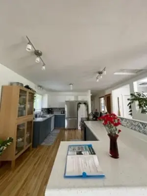 a kitchen with a table with a vase of flowers at Sweet Creek Retreat in Nelson