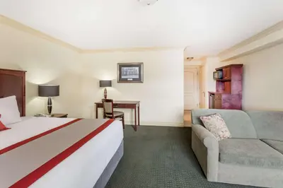 a hotel room with a bed and a couch at Ramada by Wyndham Hinton in Hinton