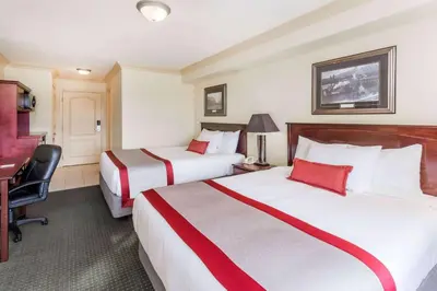 a hotel room with two beds and a desk at Ramada by Wyndham Hinton in Hinton