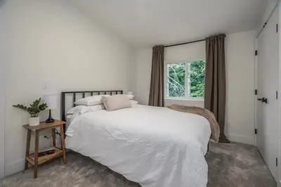 a bedroom with a white bed and a window at Black Diamond Cabin - Sasquatch Mountain Resort in Agassiz