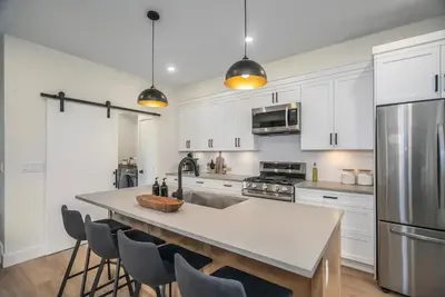 a kitchen with white cabinets and a large kitchen island at Black Diamond Cabin - Sasquatch Mountain Resort in Agassiz