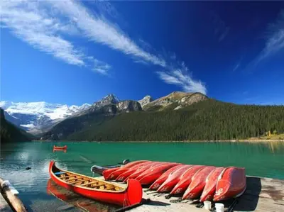 a group of red canoes sitting on top of a lake at The Grand Escape Downtown Canmore in Canmore