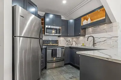 a kitchen with blue cabinets and a stainless steel refrigerator at Mountain Vista Escape Downtown in Canmore