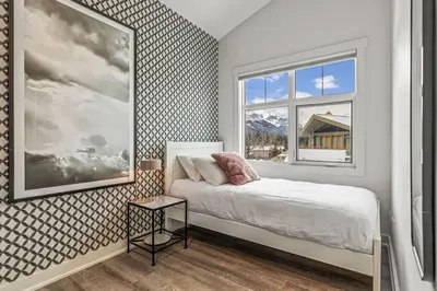 a bedroom with a bed and a window at Mountain Vista Escape Downtown in Canmore