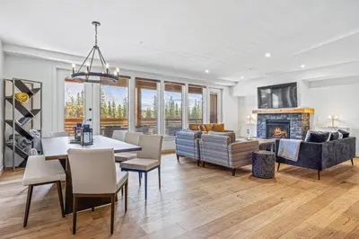 a dining room and living room with a fireplace at Serenity Villa at Tamarack in Canmore