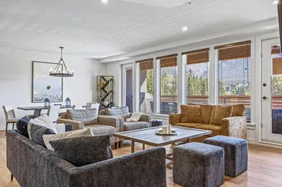 a living room with couches and a table at Serenity Villa at Tamarack in Canmore