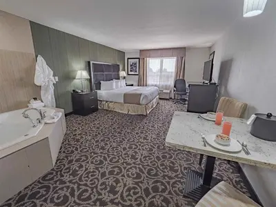 a hotel room with a bed and a television at Paradise Inn and Suites Redwater in Redwater