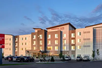 a large building with cars parked in a parking lot at TownePlace Suites by Marriott Fort McMurray in Fort McMurray