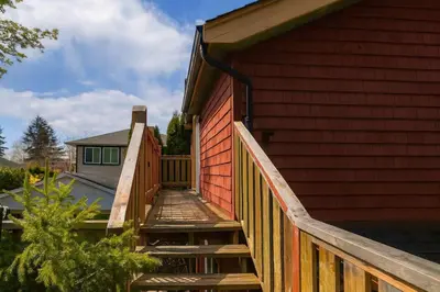 a wooden ramp leading up to a house with a fence at Charming 