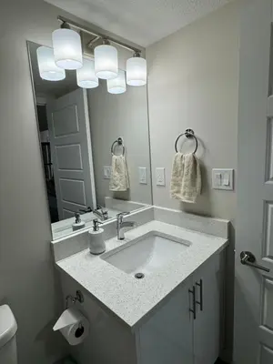 a bathroom with a sink and a large mirror at Brand new 2 Bedrooms modern guest suite with separate entrance in Calgary