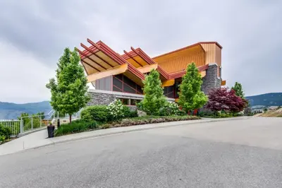 a house on a hill with a road in front of it at Top Floor Lakeview Condo at Copper Sky 509 in West Kelowna