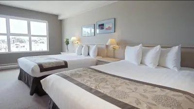 a hotel room with two beds and a window at Quarterdeck Inn Port Hardy in Port Hardy