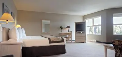 a hotel room with a bed and a television at Quarterdeck Inn Port Hardy in Port Hardy