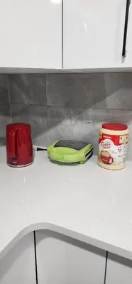 a green phone on a counter next to a can of soup at Cozy One bedroom BSMT Apartment in Edmonton
