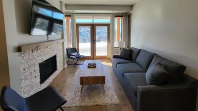 a living room with a couch and a fireplace at Powder Heights #22 townhouse in Sun Peaks