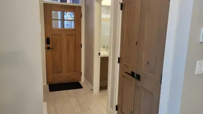a hallway with a wooden door and a sink at Powder Heights #22 townhouse in Sun Peaks