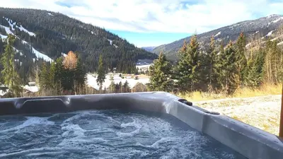 a jacuzzi tub with a view of a mountain at Powder Heights #22 townhouse in Sun Peaks