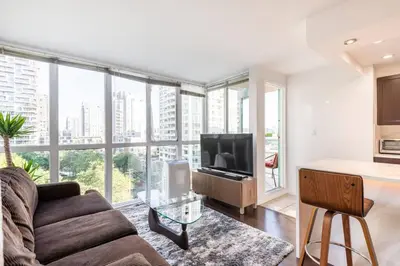 a living room with a couch and a television at Luxury 2-bedroom condo beach side Yaletown in Vancouver