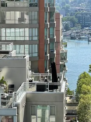 an apartment building with a view of the water at Luxury 2-bedroom condo beach side Yaletown in Vancouver