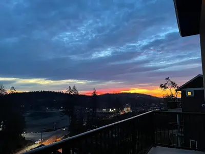 a view of a sunset from the balcony of a house at Guest room with private bath in Langford in Victoria